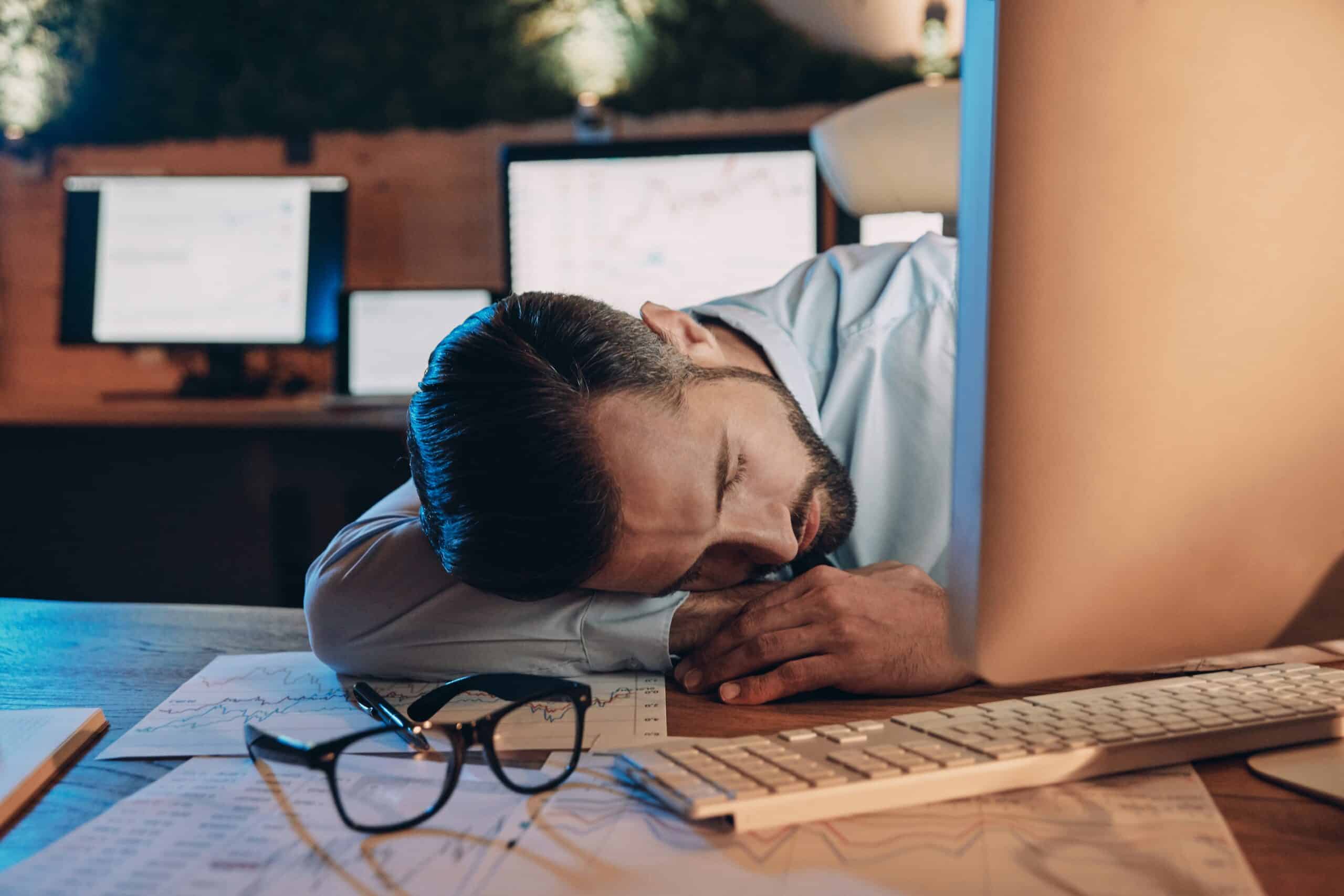 Alert fatigue SOC: vermoeide SOC-analist staart naar dashboard met overweldigend aantal openstaande security alerts
