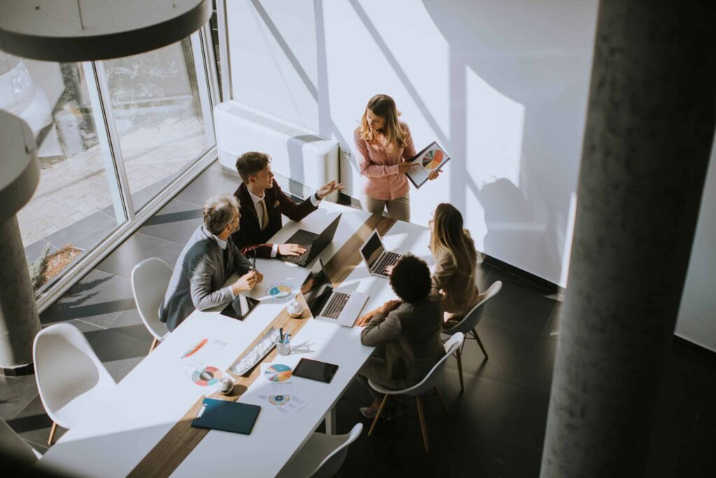 Cybersecurity boardroom: CISO presenteert security-risico's en businesscase aan MT met CFO en CEO in vergaderruimte met financiële dashboards