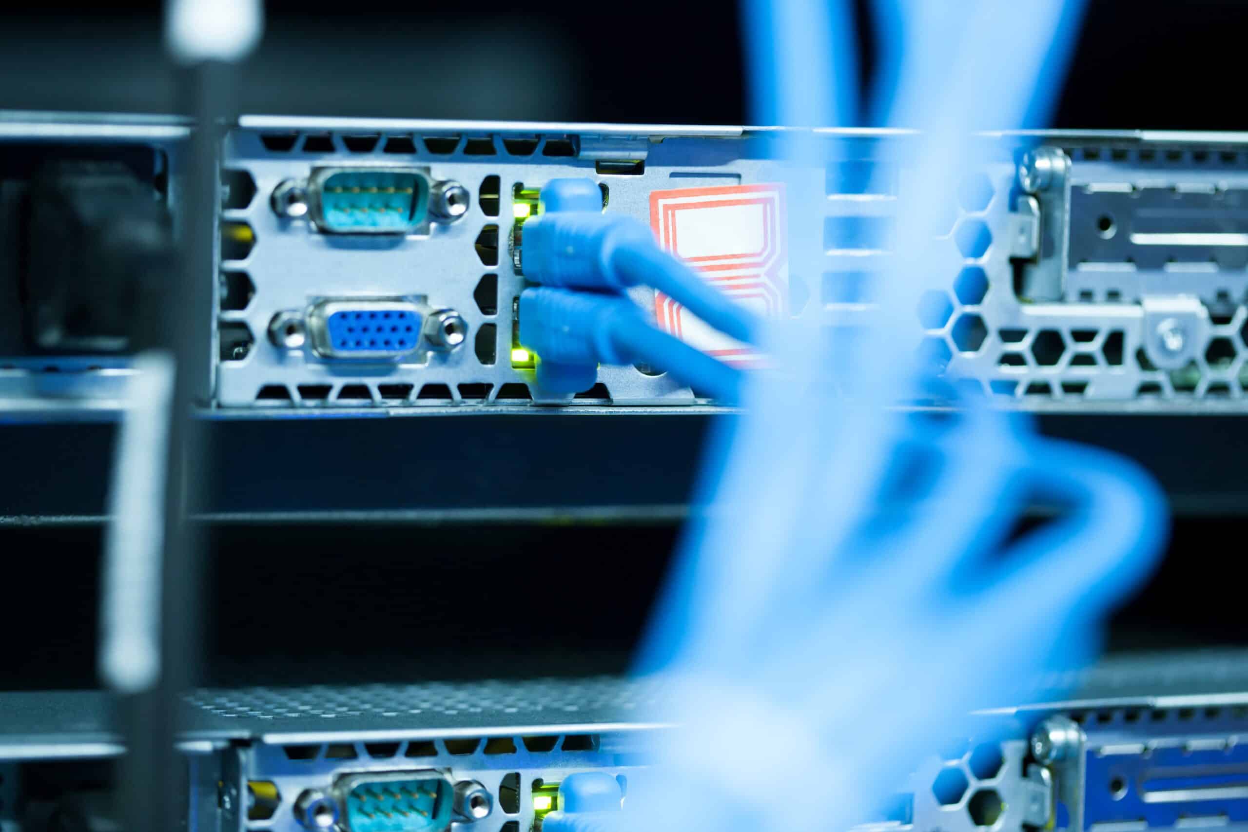 OT security analist in fabrieksomgeving bekijkt SCADA-dashboard met Modbus-protocolverkeer, terwijl IT-collega notities maakt over productieproces